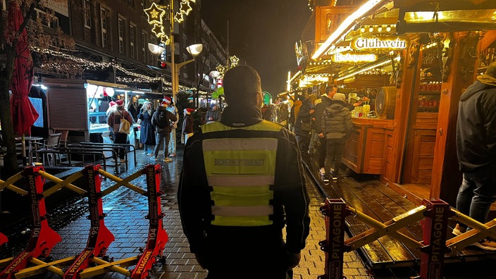 Duisburger Weihnachtsmarkt: Eingangsbereich mit Stahlbarrieren und Sicherheitskraft