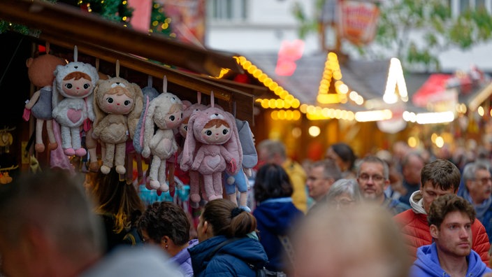 Weihnachtsmarkt Essen - Puppen hängen an einem Verkaufsstand