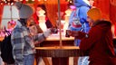 Ein Mann und eine Frau trinken Glühwein auf dem Duisburger Weihnachtsmarkt.