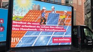 Das Foto zeigt ein Werbeplakat der Handwerkskammer Düsseldorf auf einem Lkw, angefertigt wurde es von Jacques Tilly