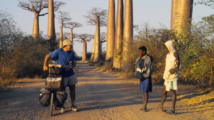 Heinz Stücke redet in Afrika auf der Straße mit zwei Jungen.