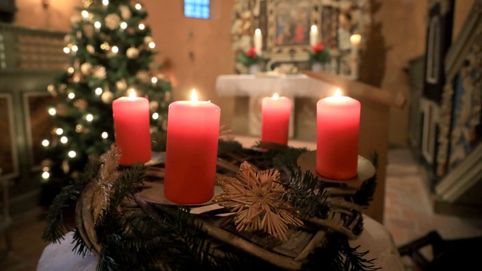 Adventskranz und Weihnachtsbaum in einer Kirche