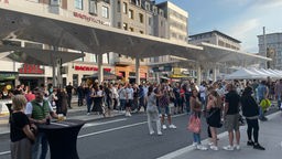 Feiernde Menschen vor der Bushaltestelle des wiedereröffneten Bielefelder Jahnplatzes