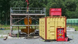 Eine Ölkaverne, vor der ein Stahlcontainer steht.