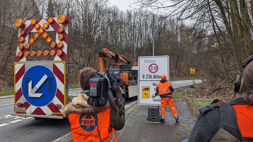 Ein Kamerateam filmt den Aufbau von Straßenschildern