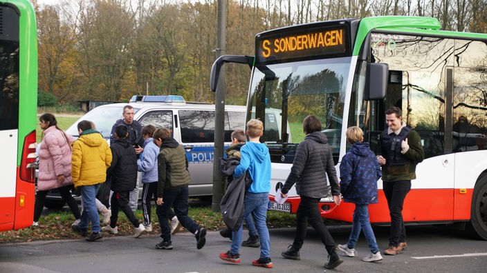 Schüler steigen in Busse ein, die sie zu einer Sammelstelle bringen 