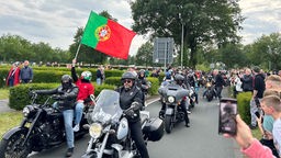 Eine Gruppe von Motorradfahrern hisst die portugiesische Flagge