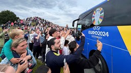 Schaulustige schießen Fotos vom Bus der portugiesischen Nationalmannschaft