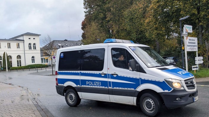 Ein Polizeiauto fährt vor dem Bahnhof in Arnsberg.