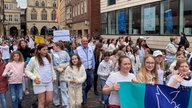 Der Sternmarsch in der Innenstadt von Münster mit einer großen Menschenmenge mit Plakaten.