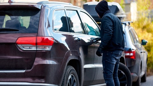 Autodieb beim Stehlen von einem Auto 