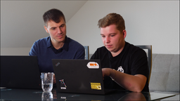 Die beiden Forscher Tim Philipp Schäfers (links) und Niklas Klee (rechts) vor ihren Laptops an einem Tisch