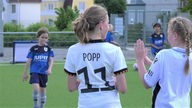 Mädchen trägt Fußball-Trikot mit der Aufschrift  "Popp".