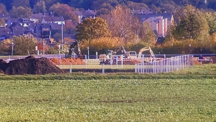 Auf einem Feld wird eine Bombe ausgegraben und entschärft.