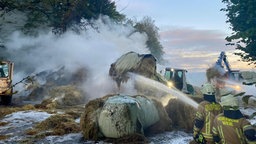 Die Feuerwehr löscht brennende Strohballen in Wiehl