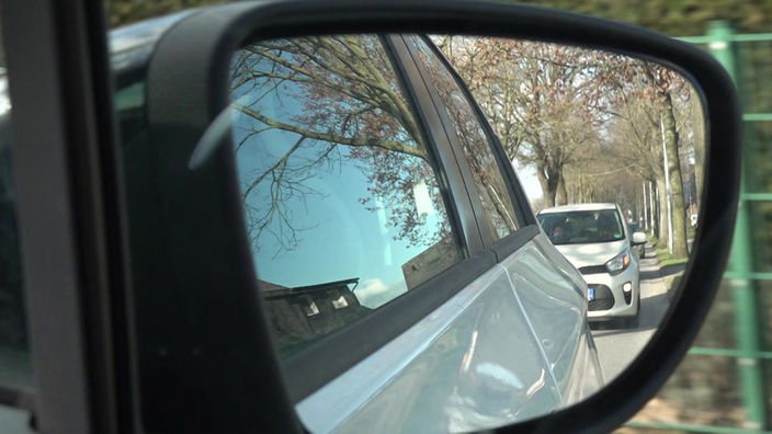 Foto von Auto-Außenspiegel, darin weiteres Autos zu sehen