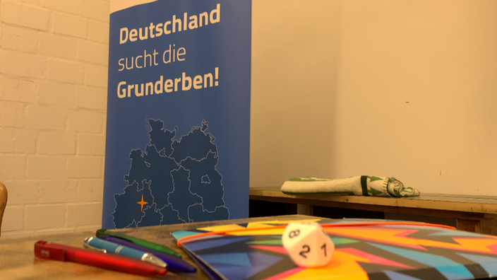 Ein blaues Banner, beschriftet mit "Deutschland sucht die Grunderben!"