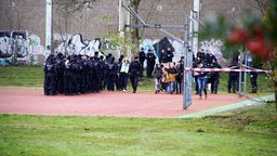 Schüler werden unter Polizeischutz auf den Sportplatz gebracht