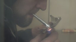 Mann raucht Heroin
