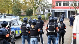 SEK-Kräfte gehen mit Westen und Waffen auf den Eingang einer Schule zu