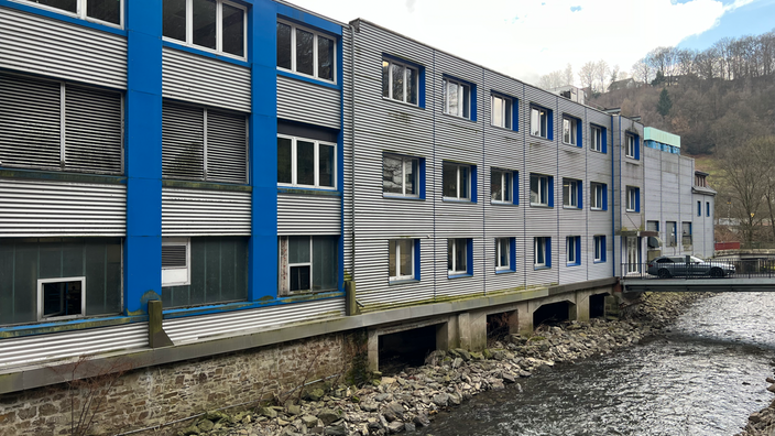 Die Außenfassade eines Gebäudes liegt direkt an einem Fluss.