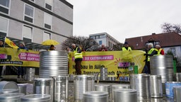 Die Protestierenden mit Plaketen und Fässern vor dem OVG Münster