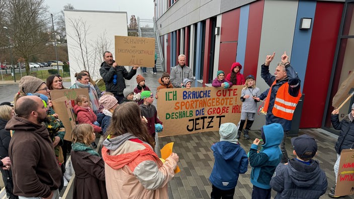 Kinder und Eltern haben sich versammelt und protestieren