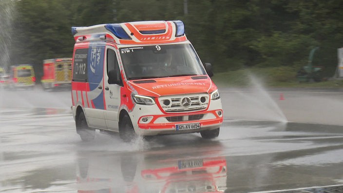 Rettungswagen, der durch Wasserfontänen fährt