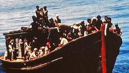 Vollbesetztes Flüchtlingsboot auf offenem Meer