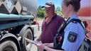 Polizistin zeigt einem LKW-Fahrer einen Flyer
