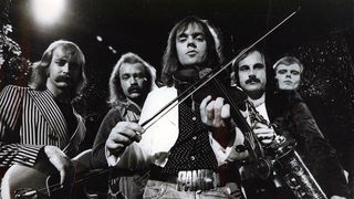 Fünf Männer in den Siebzigerjahren mit Instrumenten in Schwarz-Weiß.