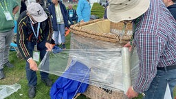 Zum Schutz vor Kälte wird ein Ballon-Korb mit Folie eingewickelt