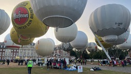 Mehrere Heißluftballone am Boden vor dem Start