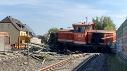 Der entgleiste Zug liegt zertrümmert auf den Schienen
