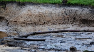 Ein Schlauch liegt am 02.05.2014 in Gronau in einem Loch auf einer Weide, auf der Öl gefunden wurde.