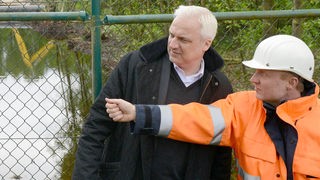 NRW-Landeswirtschaftsminister Garrelt Duin (SPD,l) und Dezernent Peter Dörne schauen sich am 02.05.2014 in Gronau (Nordrhein-Westfalen) die Umweltverschmutzung durch Öl auf einer Weide an.