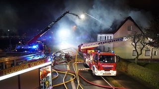 Die Feuerwehr löscht einen Hausbrand mit einer Drehleieter