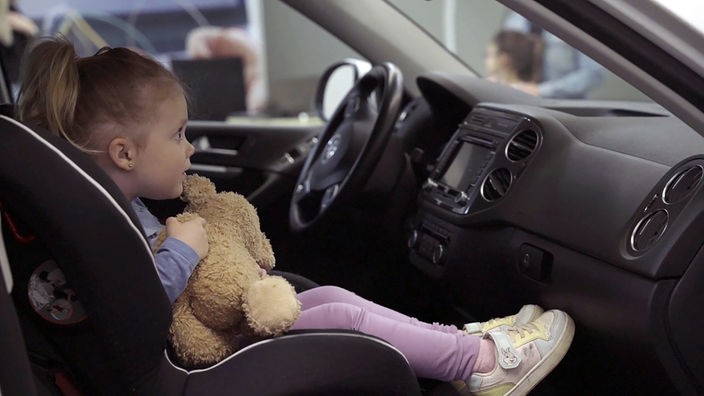 Ein Kind in einem Auto auf dem Kindersitz vorn