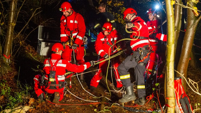 In rot gekleidete Rettungskräfte versorgen den Verunfallten im Wiehengebirge.