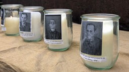 Kerzengläser mit Bildern von Holocaust Opfern.