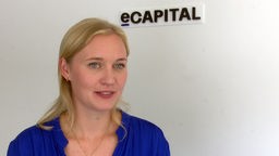 Ann-Christin Kortenbrede vor dem Logo der e-Capital