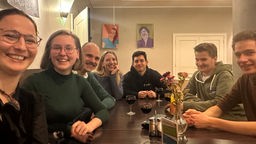 Die Gruppe der sieben Jungen Europäischen Föderalisten aus Münster an einem Tisch.
