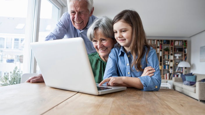 Kind und Senioren vor einem Computer 