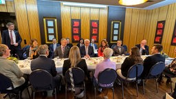 Bundespräsident Steinmeier sitzt mit weiteren Menschen an einer Kaffeetafel
