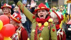 Eine in schwar-rot-gelben Kostüm verkleidete Karnevalistin jubelt am Nelkendienstag in Olfen.