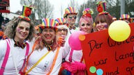 Mit bunten Hüten verkleidete, geschminkte KarnevalistInnen am Nelkendienstag in Olfen.