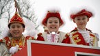 Drei junge Jecken in traditioneller Karnevalskostümierung am Nelkendienstag in Olfen.