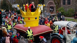 Karnevalswagen mit riesiger Krone auf einem Samtkissen