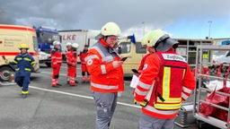 Einsatzkräfte in Warnwesten versammeln sich für eine Katastrophenschutzübung