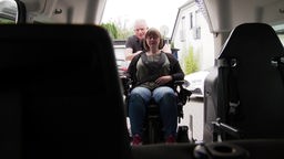 Eine Frau im Rollstuhl wird von dem Krankenfahrdienst abgeholt